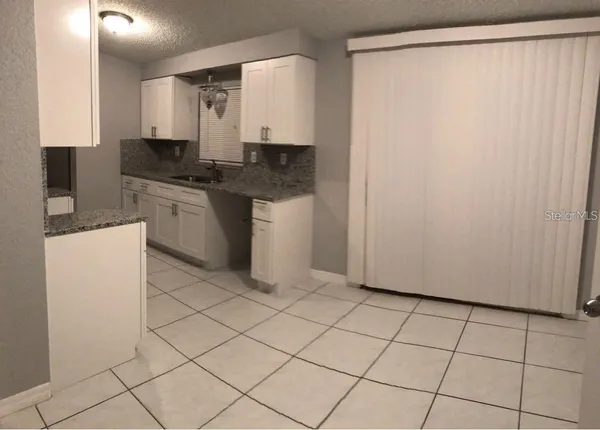 a kitchen with a sink a stove top oven and cabinets