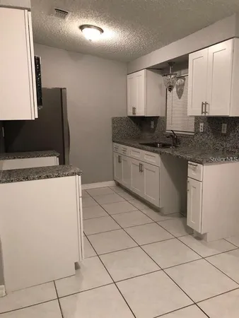 a bathroom with a granite countertop sink a mirror and vanity