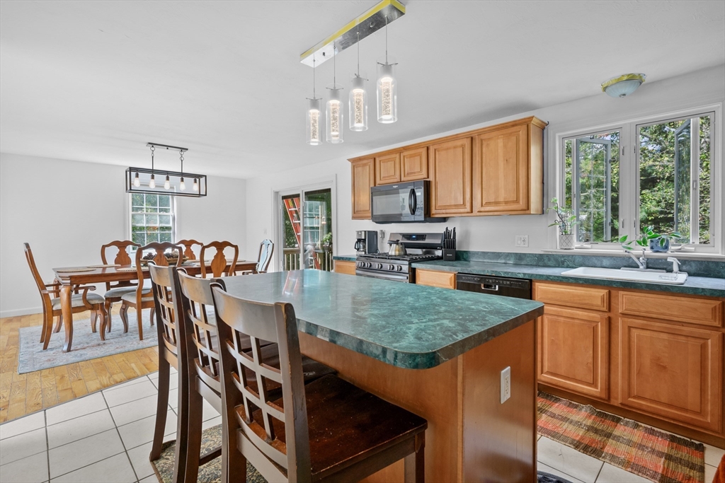 16 Balfour Lane Mashpee, MA 02649 - Photo 13 of 32 a kitchen with stainless steel appliances granite countertop a table chairs sink and cabinets