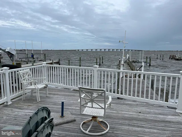 a balcony with wooden floor table and chairs