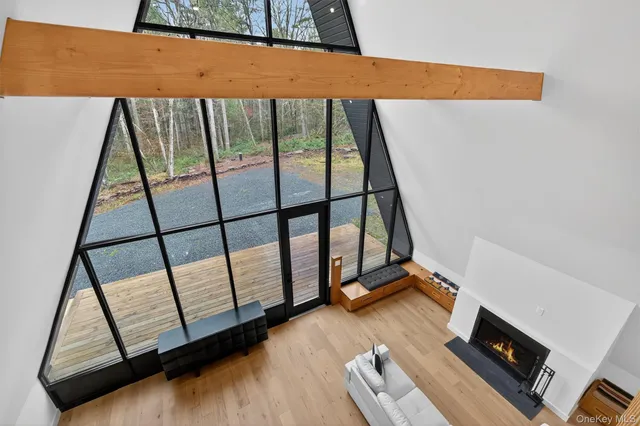 a view of an empty room with wooden floor and windows