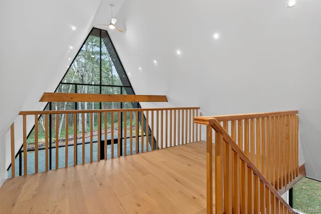 a view of staircase with a floor to ceiling window and wooden floor