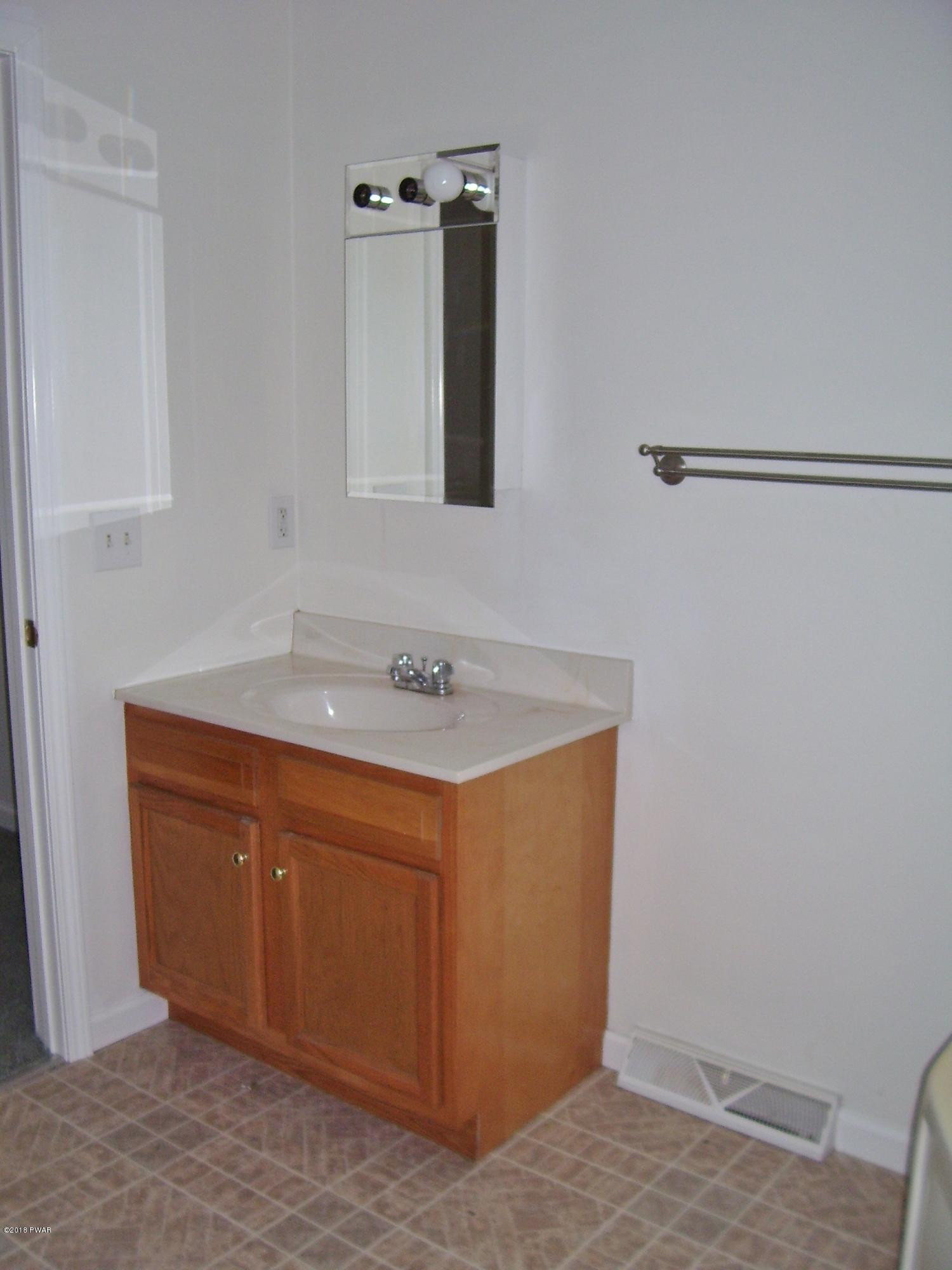13 W Road Hawley, PA 18428 - Photo 14 of 26 a bathroom with a sink and a mirror