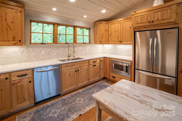 a kitchen with stainless steel appliances granite countertop a refrigerator sink and cabinets