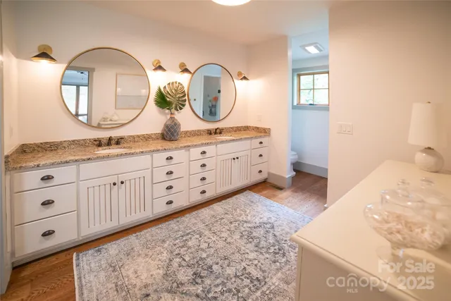 a bathroom with a granite countertop double vanity sink and a mirror