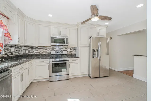 a kitchen with stainless steel appliances granite countertop a refrigerator and a stove top oven