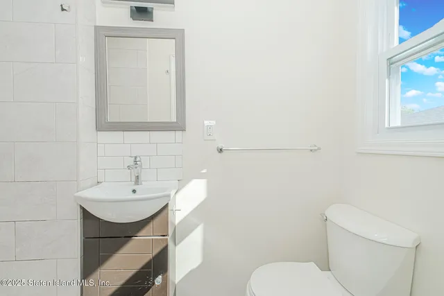 a bathroom with a sink shower and a mirror