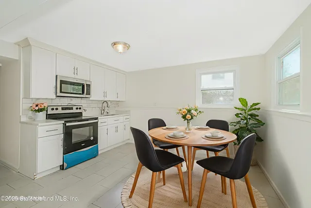 a view of a dining room with furniture a kitchen and a chandelier