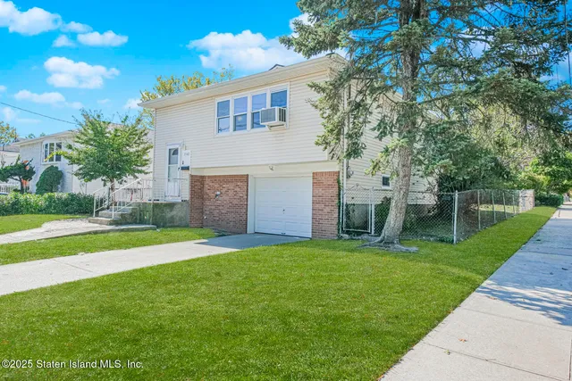 a view of a house with a yard and a tree
