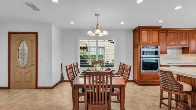 a dining room with furniture a chandelier and wooden floor