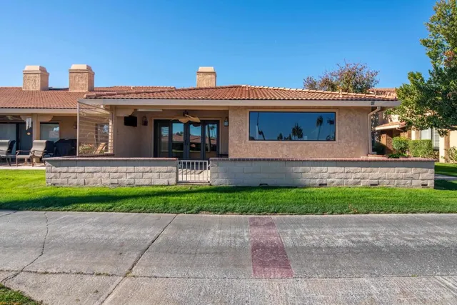 an aerial view of a house with a yard and trees in front of it