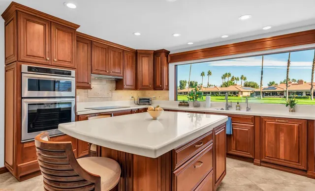 a kitchen with stainless steel appliances granite countertop a stove a sink and a refrigerator