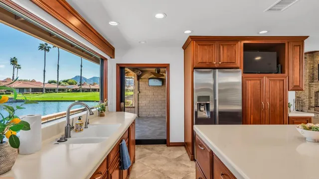 a view of a livingroom with a flat screen tv ceiling fan and windows