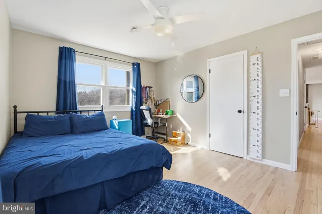 a bedroom with a bed a mirror and a large window