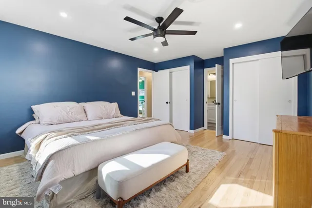 a bed room with a bed a couch and a ceiling fan