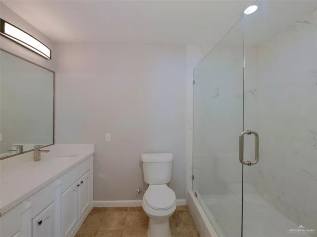 a spacious bathroom with a toilet sink and a mirror