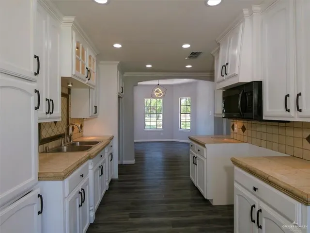 a kitchen with stainless steel appliances kitchen island granite countertop a sink and a stove