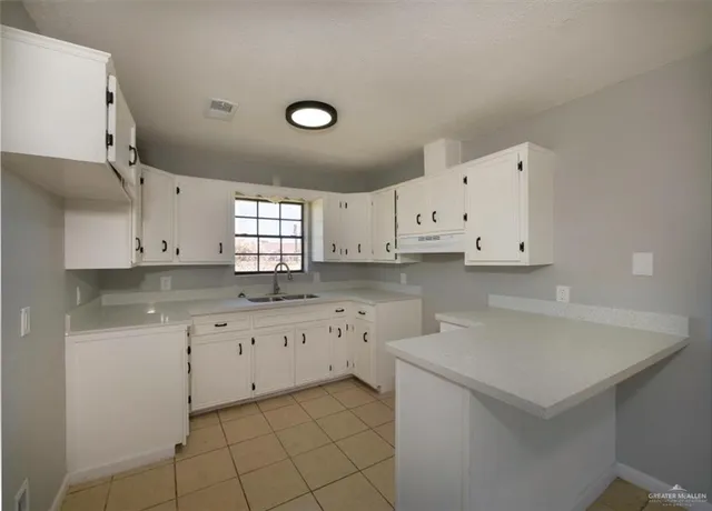 a kitchen with granite countertop white cabinets and white appliances