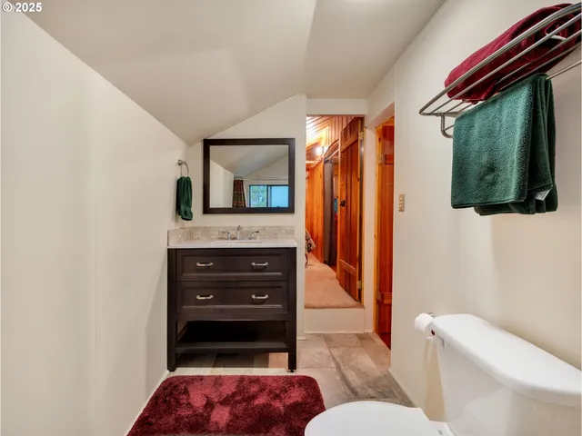 a bathroom with a toilet a sink and mirror