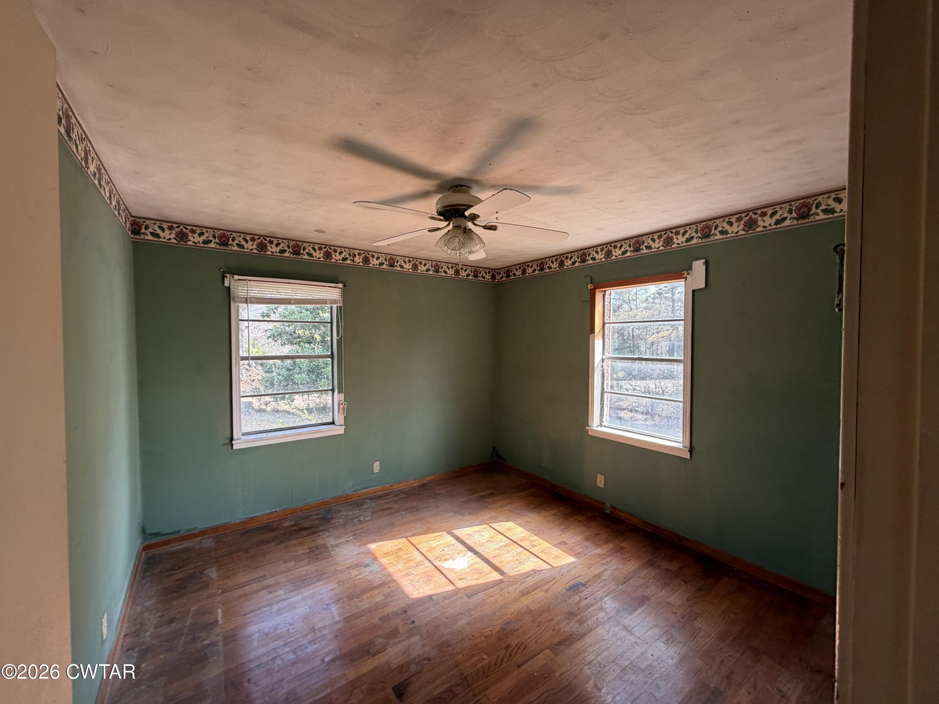 13835 Old Jackson Road Whiteville, TN 38075 - Photo 21 of 27 a view of an empty room with a window and wooden floor