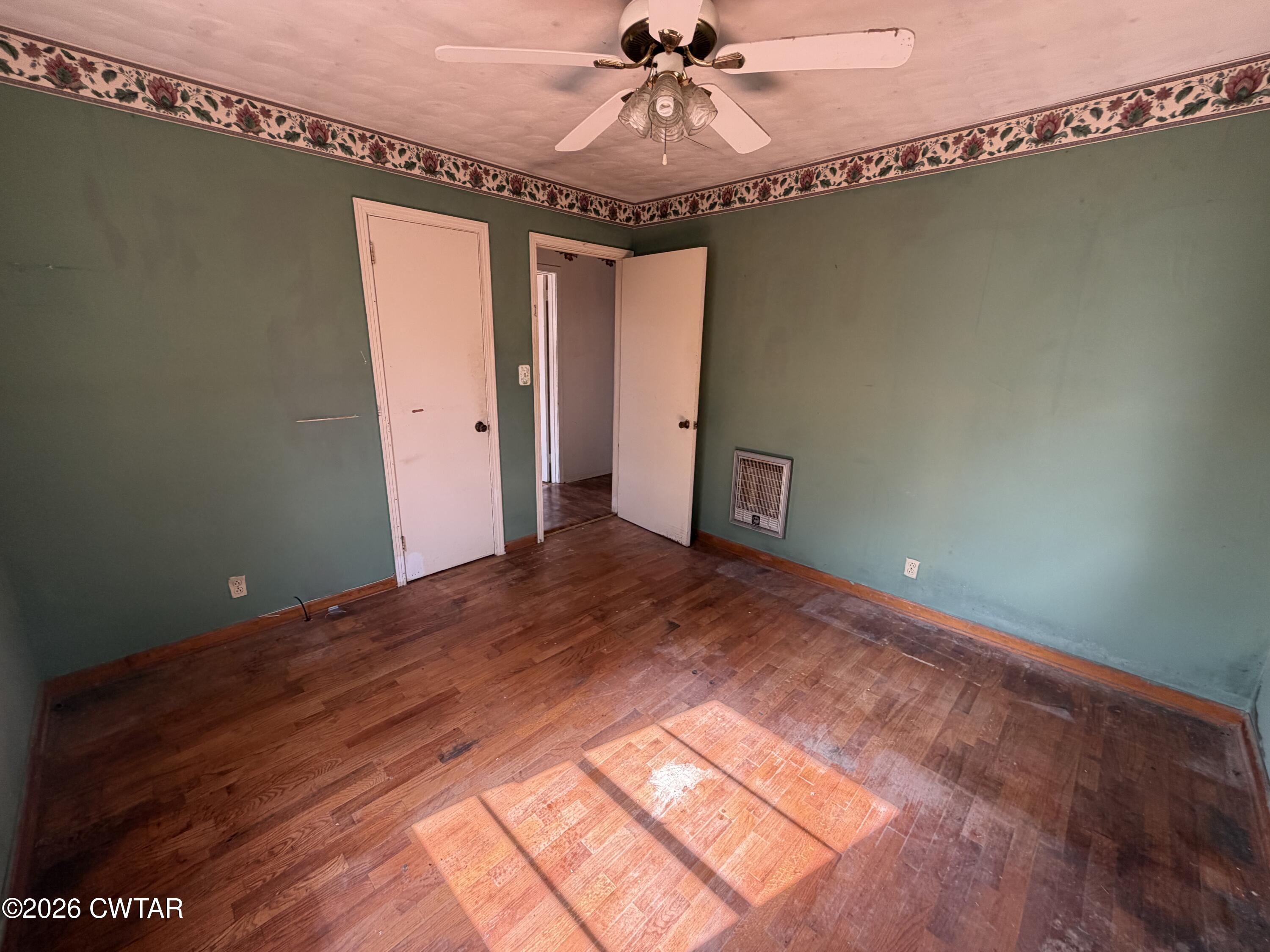 13835 Old Jackson Road Whiteville, TN 38075 - Photo 22 of 27 a view of a livingroom with wooden floor and a ceiling fan