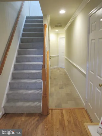 a view of staircase with white walls and a glass door