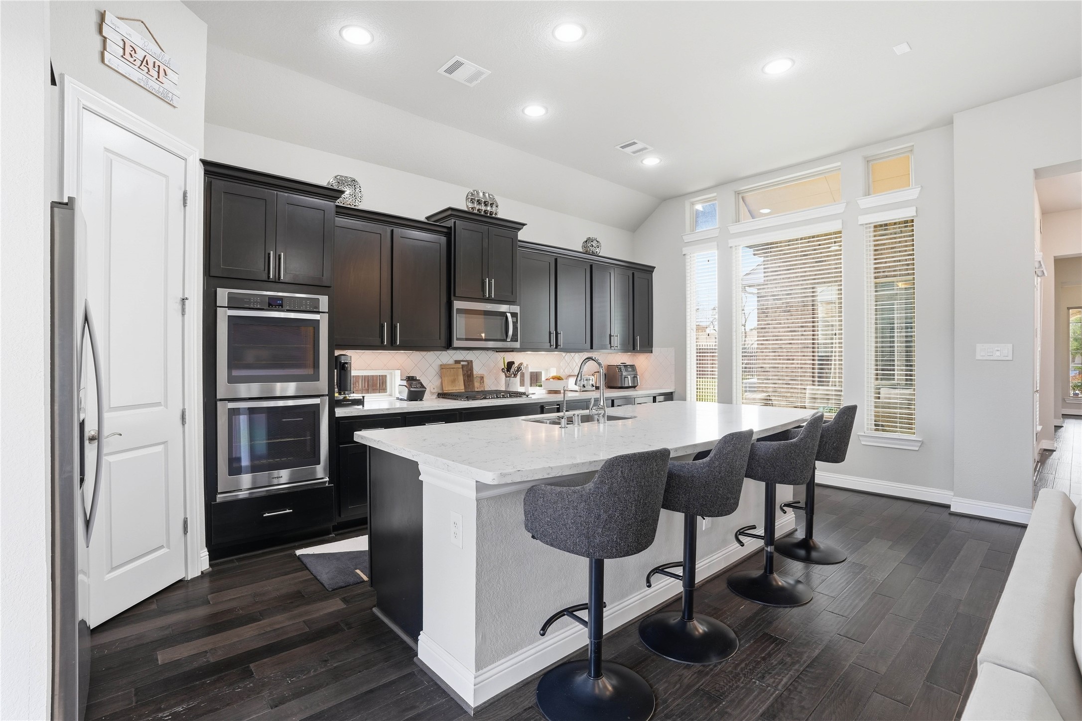 18606 Copano Lane Spring, TX 77379 - Photo 11 of 30 a kitchen with kitchen island granite countertop wooden floors and stainless steel appliances