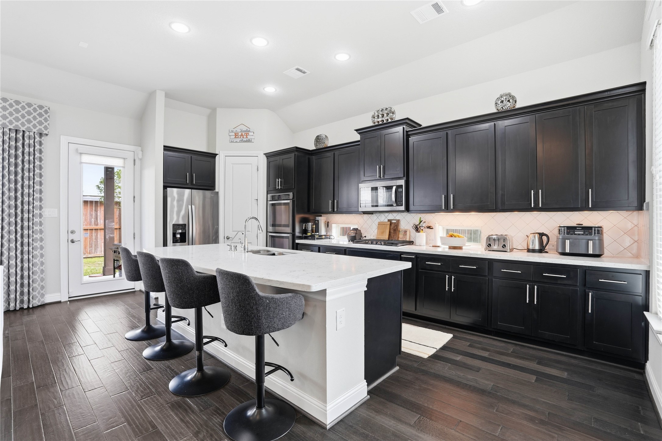 18606 Copano Lane Spring, TX 77379 - Photo 10 of 30 a kitchen with stainless steel appliances kitchen island granite countertop a table chairs sink and cabinets