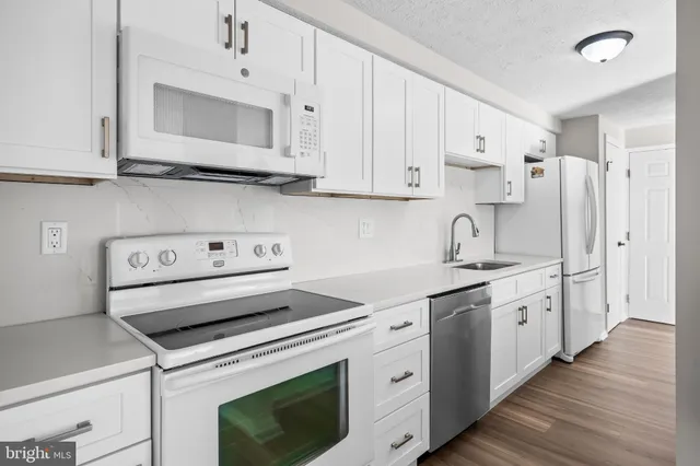a kitchen with cabinets appliances a sink and a counter top space