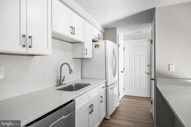 a kitchen with stainless steel appliances a refrigerator sink and cabinets