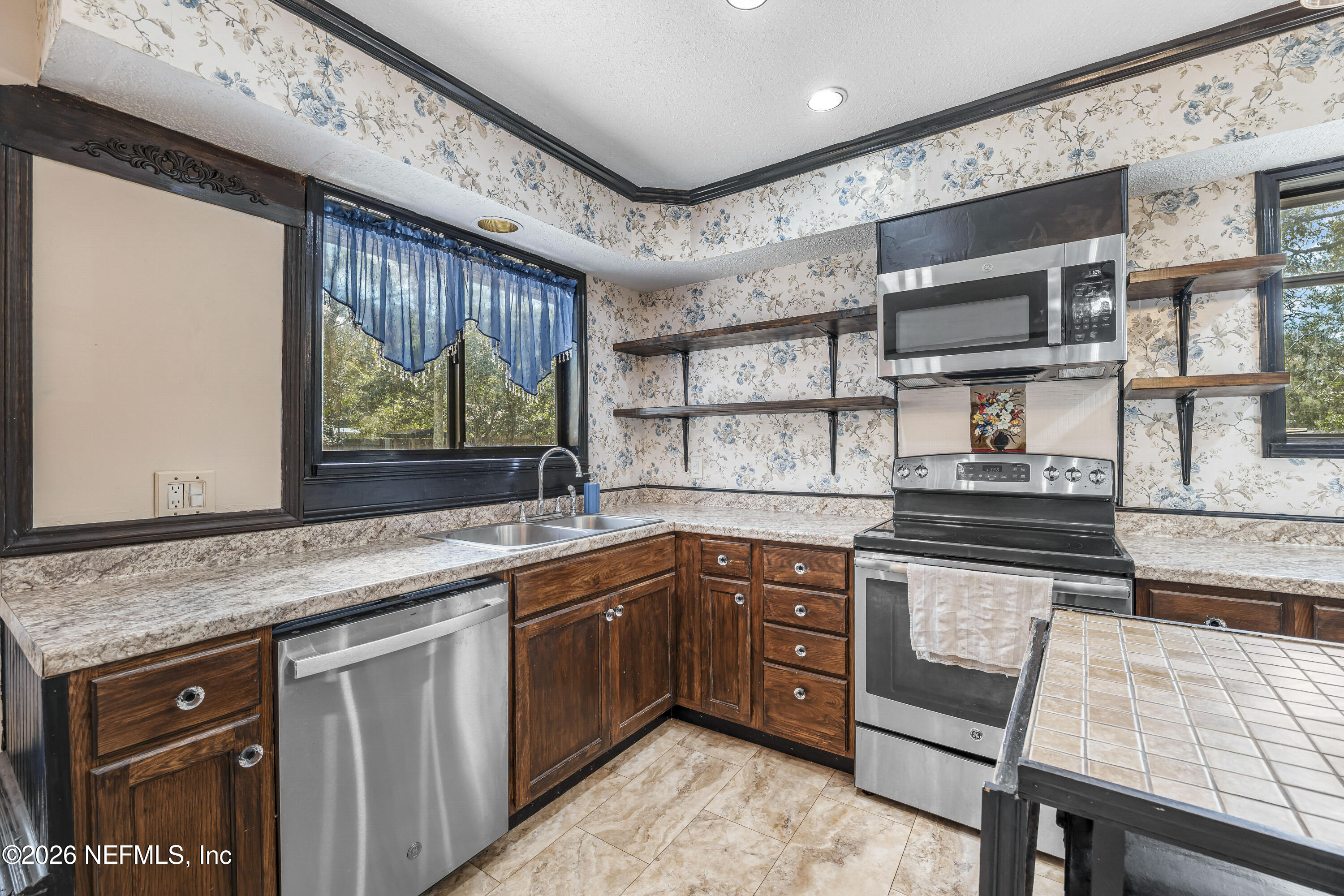 2823 Jewell Road Jacksonville, FL 32216 - Photo 18 of 59 a kitchen with stainless steel appliances granite countertop a sink stove and cabinets