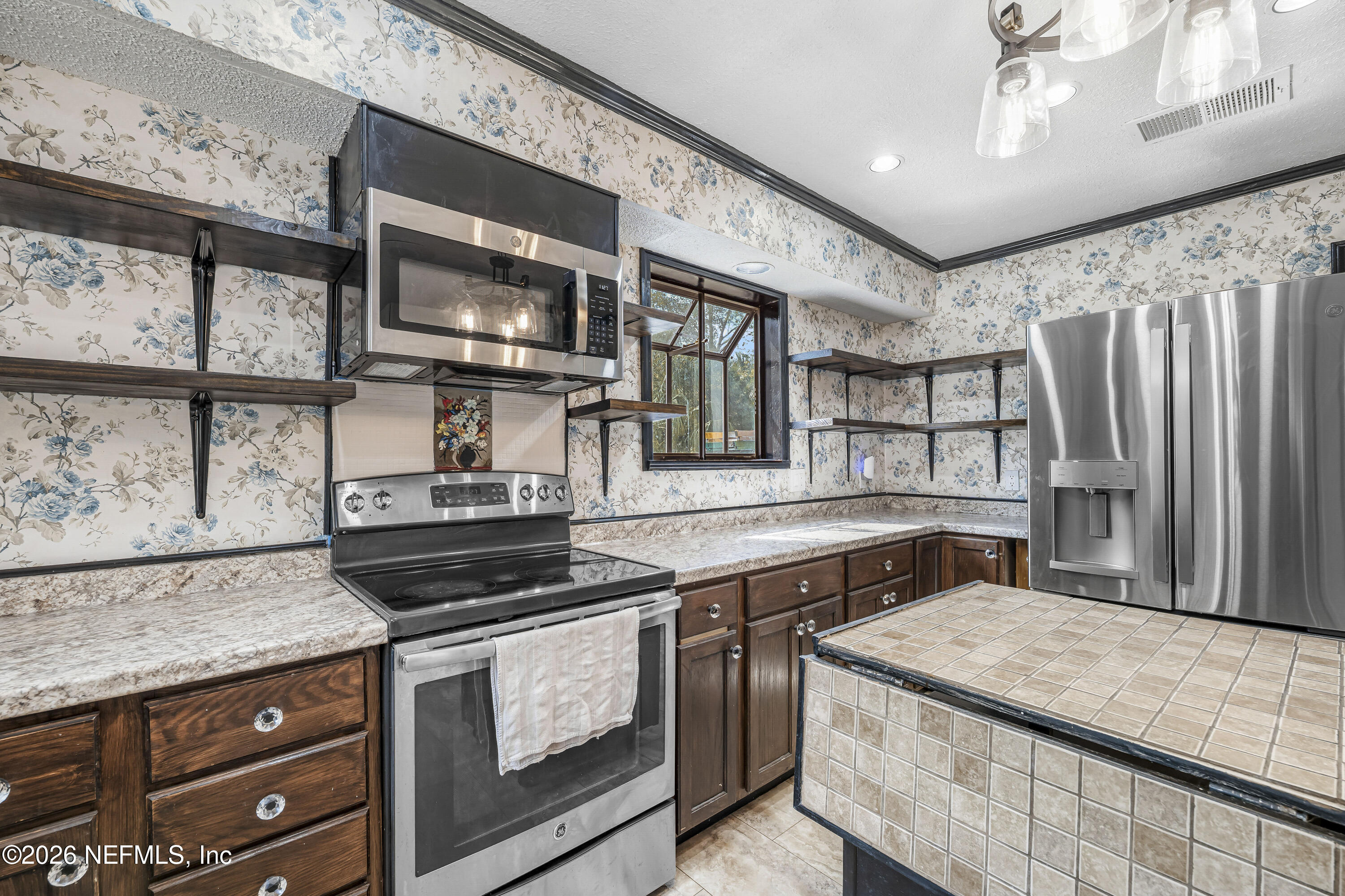 2823 Jewell Road Jacksonville, FL 32216 - Photo 19 of 59 a kitchen with stainless steel appliances a stove microwave and cabinets
