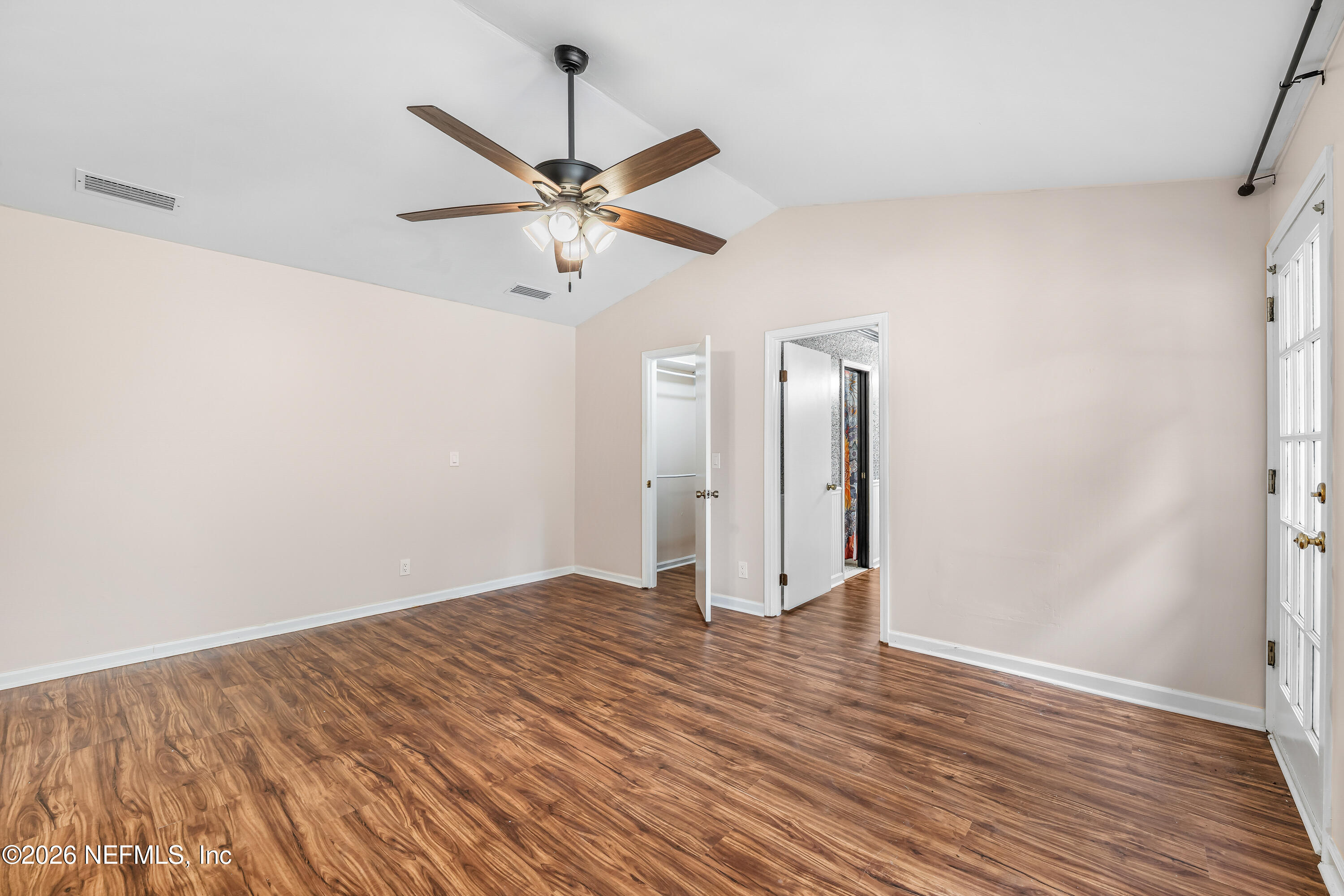 2823 Jewell Road Jacksonville, FL 32216 - Photo 24 of 59 an empty room with wooden floor fan and windows