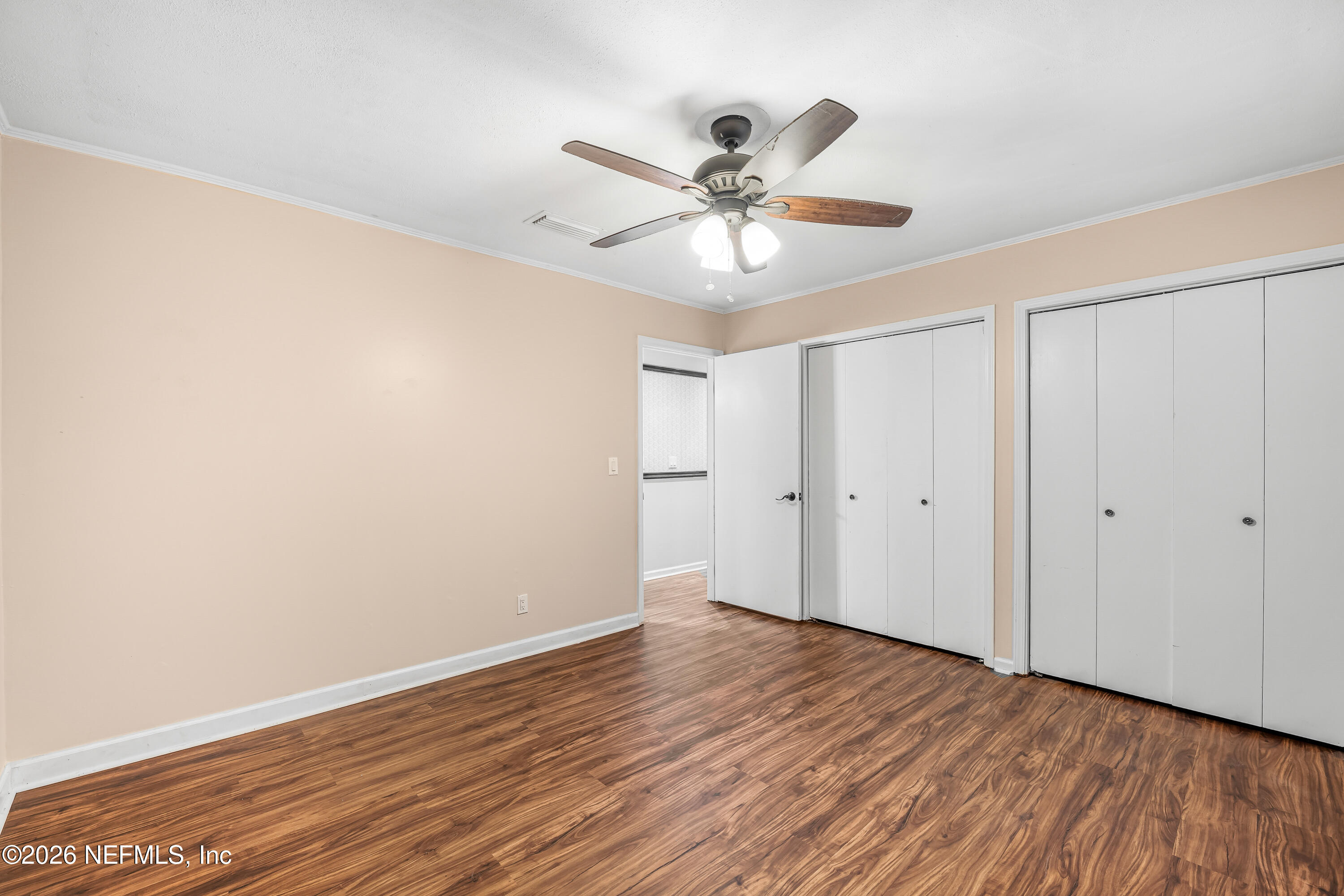 2823 Jewell Road Jacksonville, FL 32216 - Photo 33 of 59 a view of an empty room with wooden floor and a ceiling fan