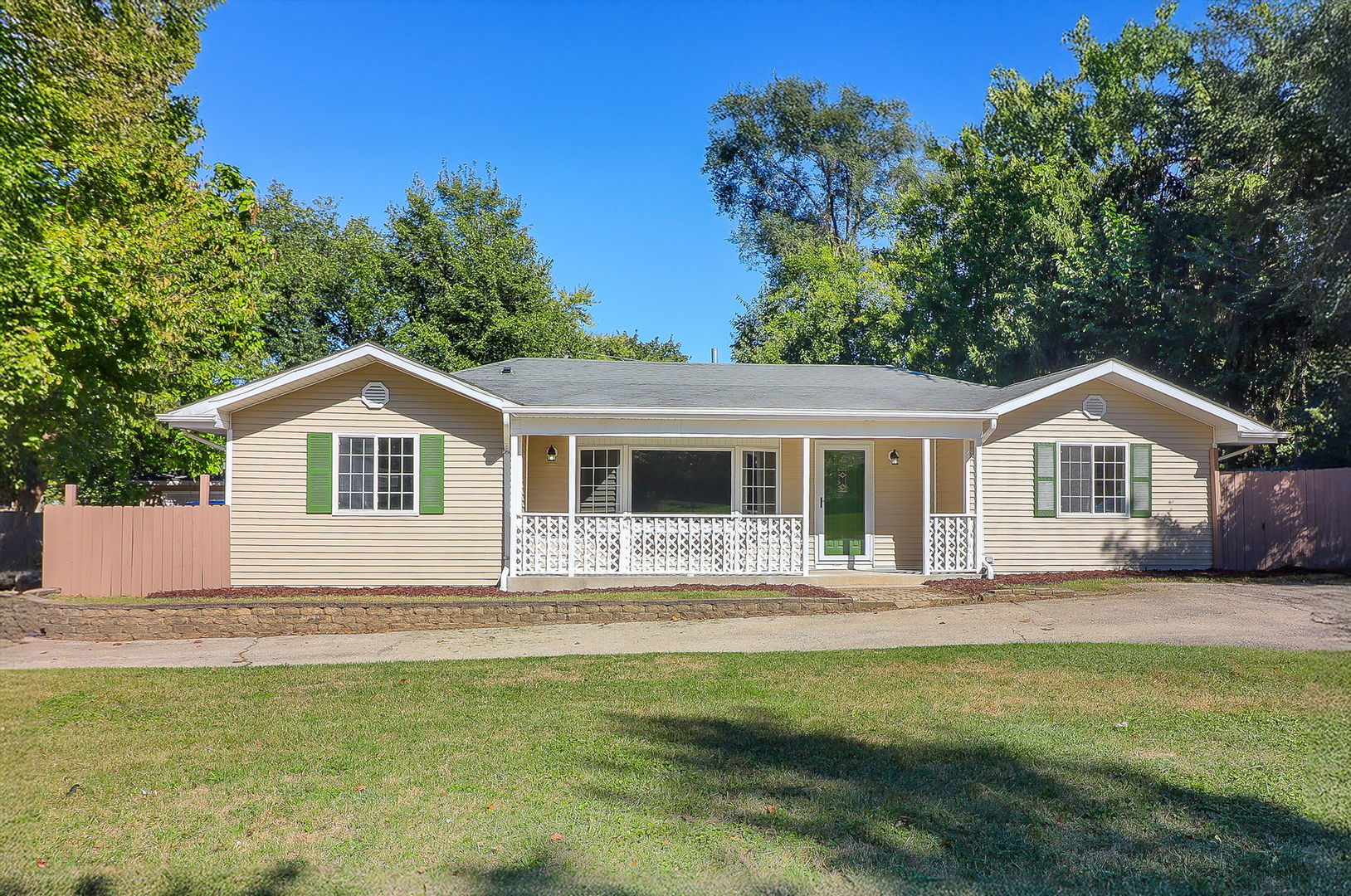 a front view of a house with a garden and yard