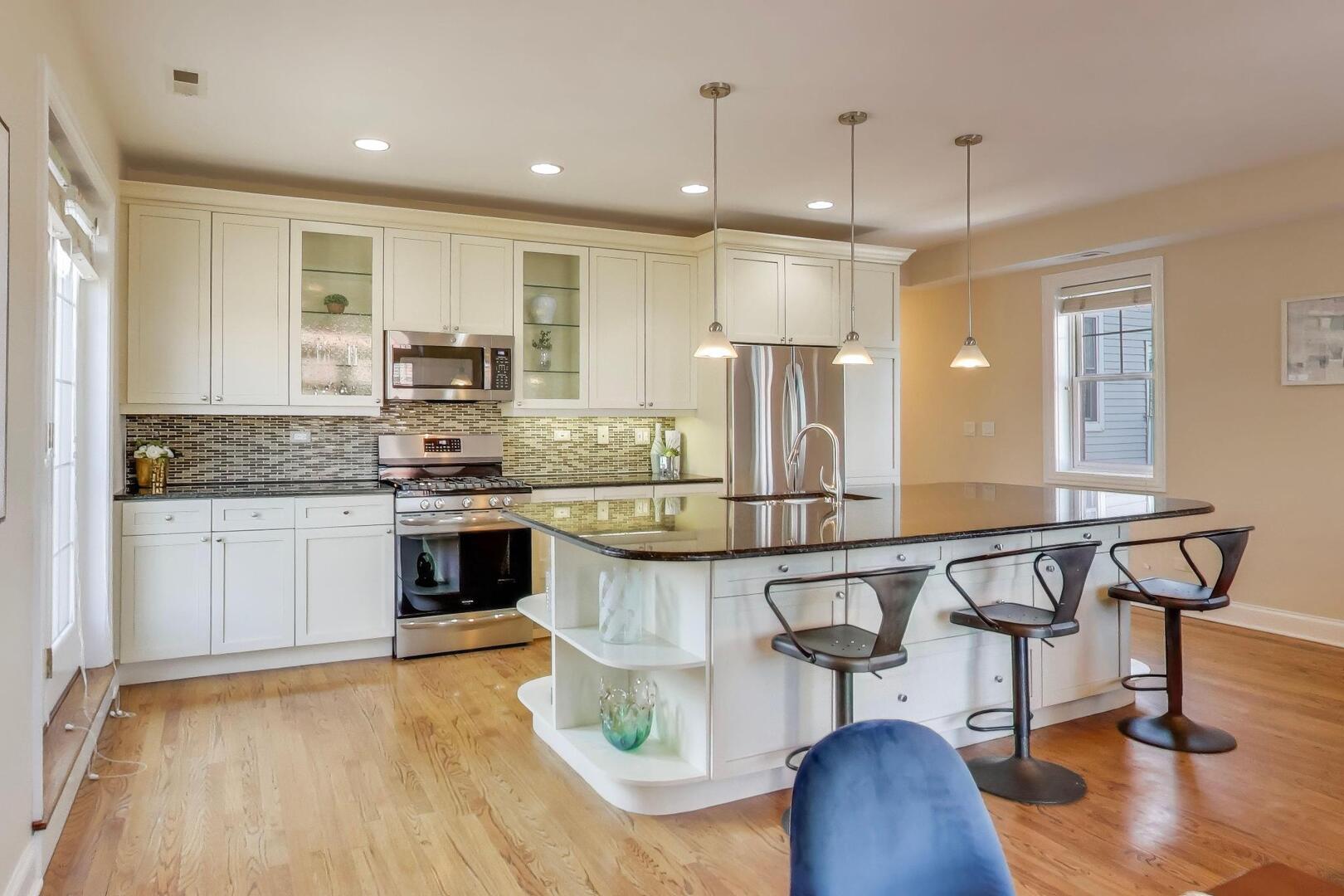 1400 West George Street, Unit 3 Chicago, IL 60657 - Photo 8 of 46 a kitchen with kitchen island stainless steel appliances a stove a sink a refrigerator and cabinets