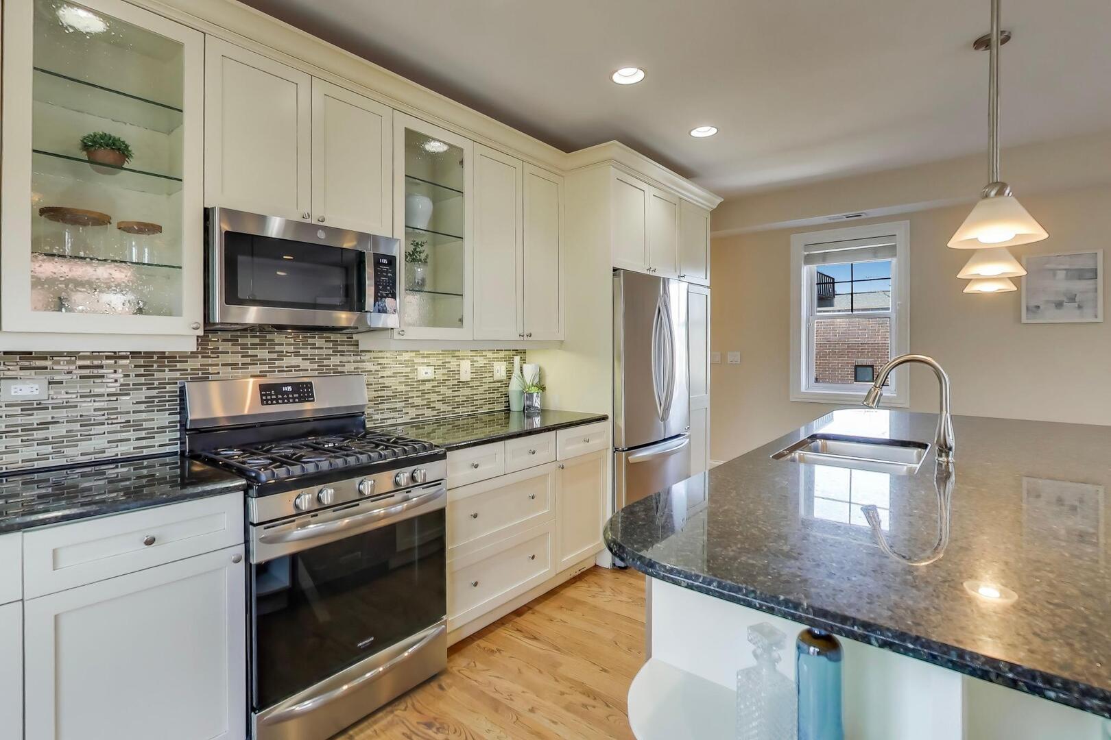 1400 West George Street, Unit 3 Chicago, IL 60657 - Photo 9 of 46 a kitchen with stainless steel appliances granite countertop a sink a stove and microwave