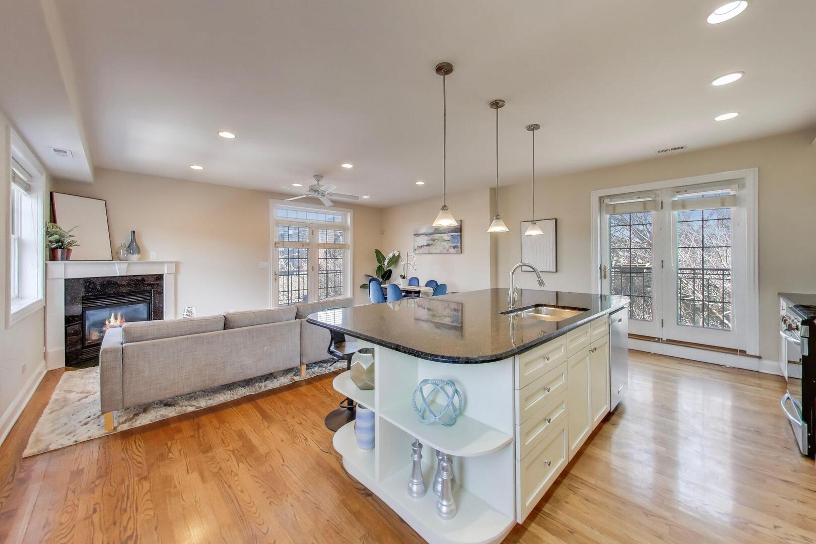 1400 West George Street, Unit 3 Chicago, IL 60657 - Photo 10 of 46 a kitchen with kitchen island granite countertop a sink a counter top space and living room view