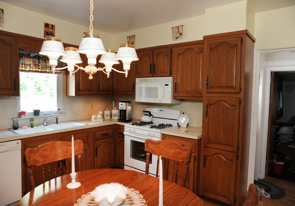 165 Betsy Brown Road Rye Brook, NY 10573 - Photo 1 of 1 a kitchen with stainless steel appliances granite countertop a sink dishwasher stove and refrigerator with wooden cabinets