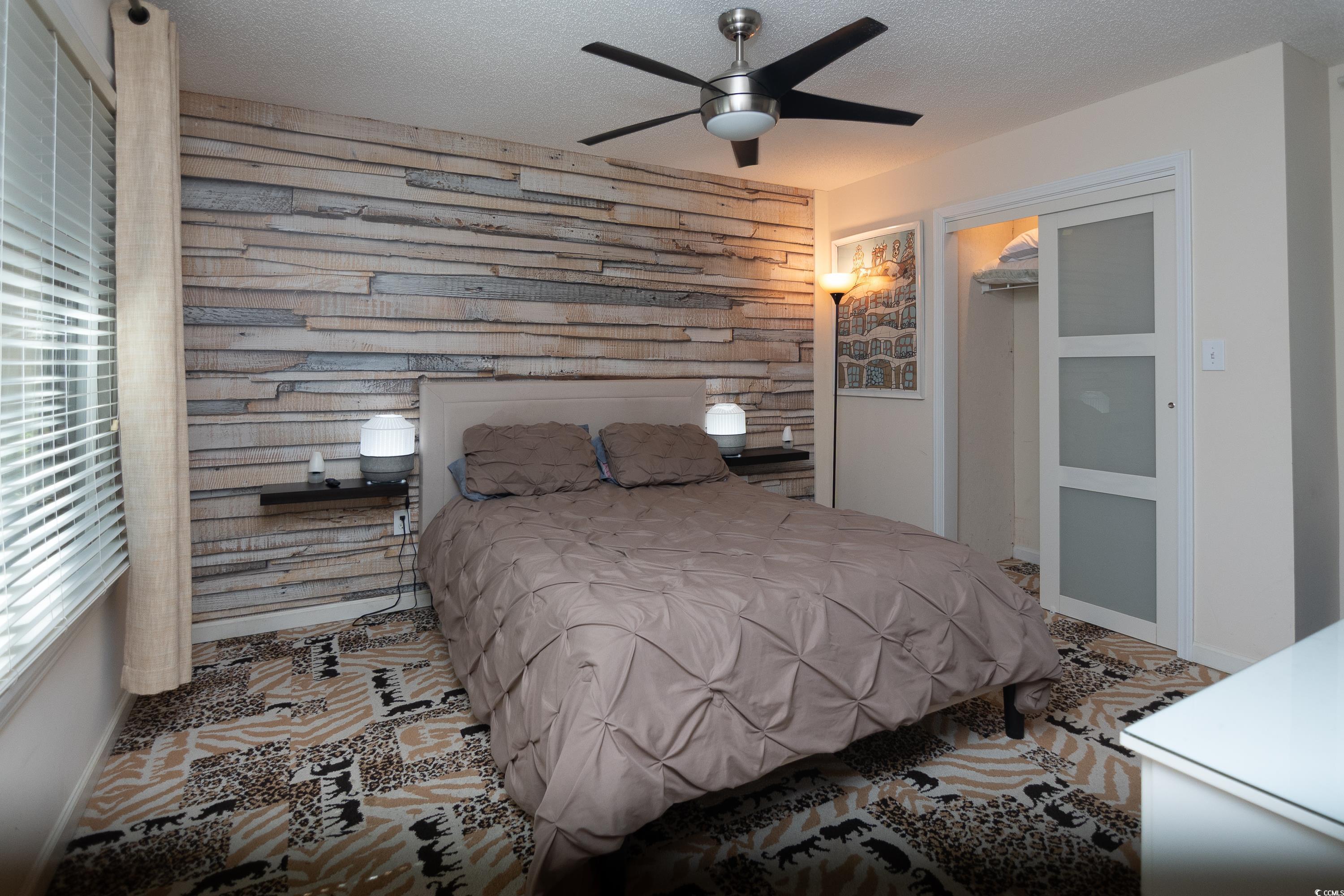 211 Baslow Court, Unit 2C Myrtle Beach, SC 29572 - Photo 15 of 33 Bedroom with a textured ceiling, wooden walls, and a ceiling fan