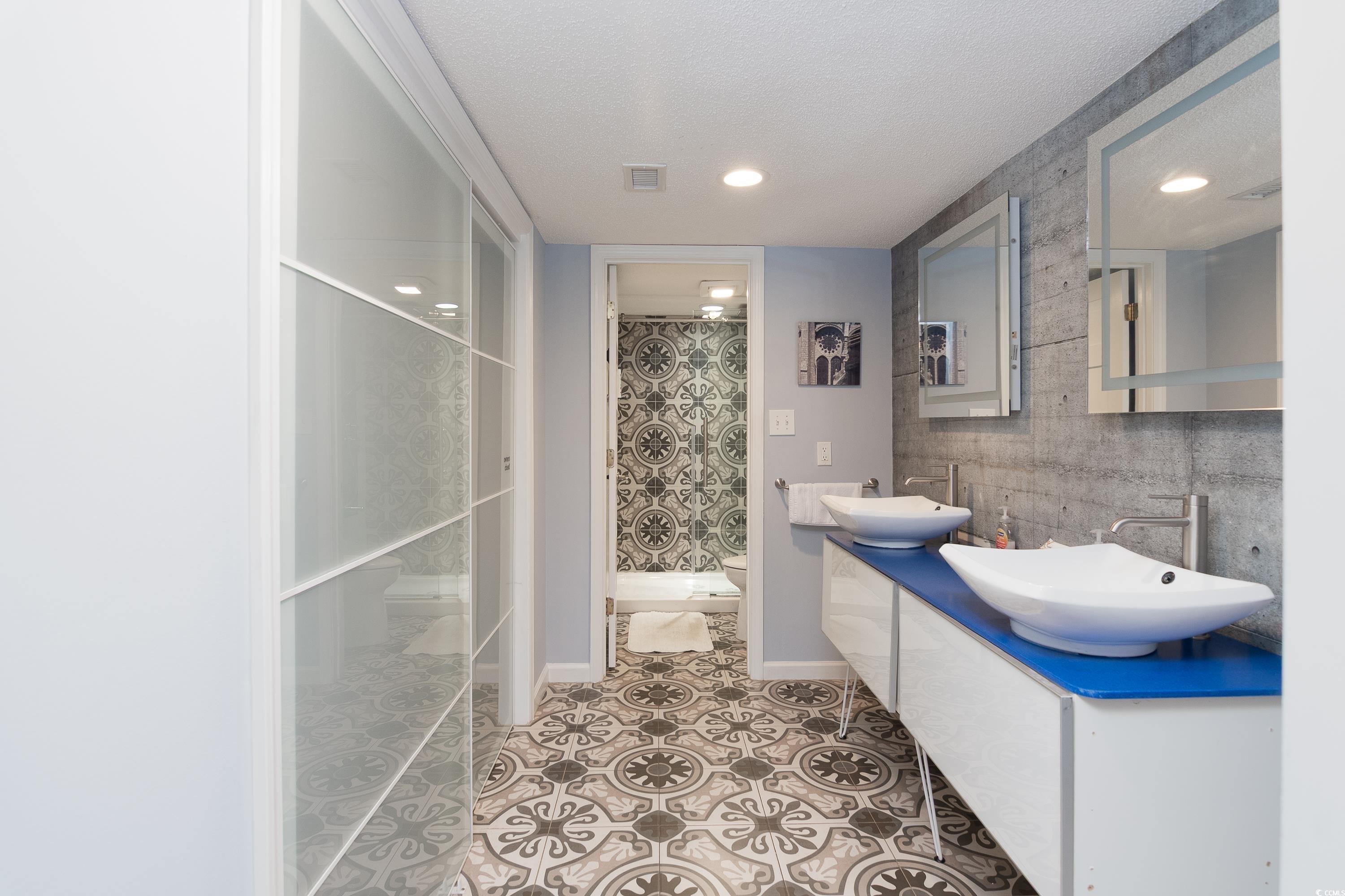 211 Baslow Court, Unit 2C Myrtle Beach, SC 29572 - Photo 22 of 33 Full bath with a shower stall, double vanity, light tile patterned floors, a textured ceiling, and recessed lighting