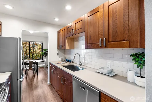 a kitchen with a sink a microwave cabinets and wooden floor