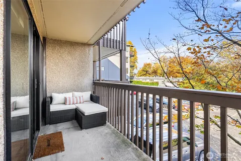 a balcony with couch and potted plants