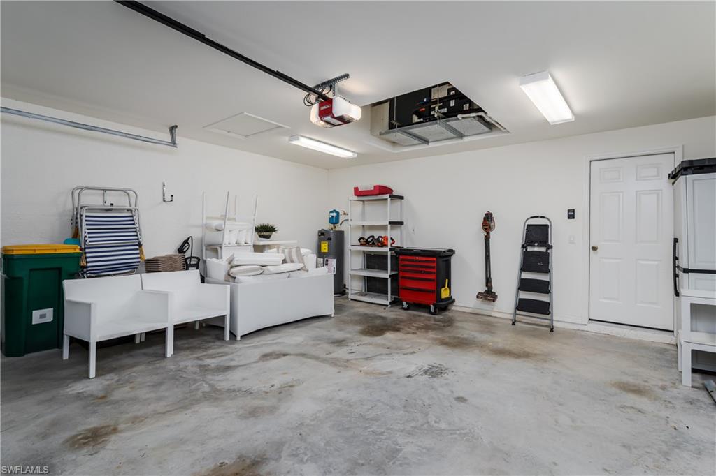 6658 Castlelawn Place, Unit 9 Naples, FL 34113 - Photo 26 of 38 Spacious garage featuring a concrete floor, white walls, and bright overhead strip lighting