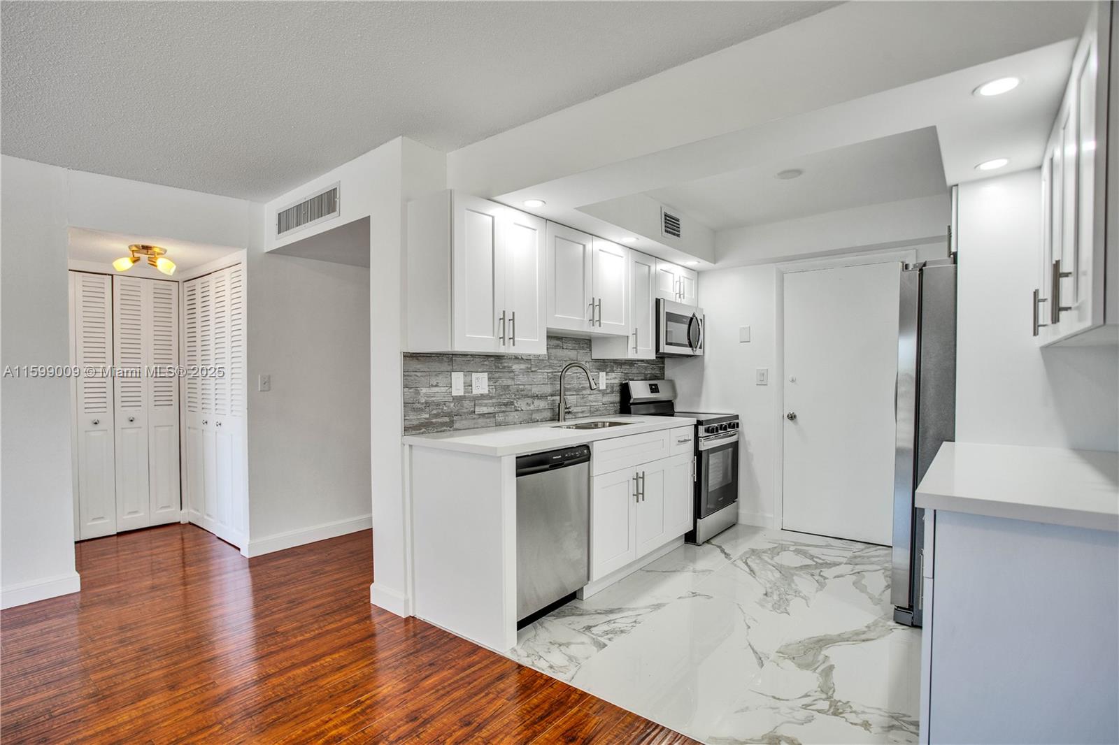 1901 South Ocean Drive, Unit 207 Hollywood, FL 33019 - Photo 15 of 47 a kitchen with a refrigerator cabinets and wooden floor
