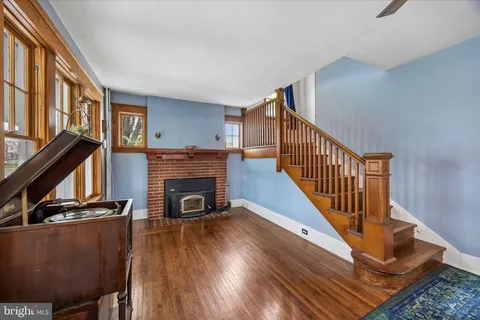 a view of a livingroom with wooden floor and a fireplace