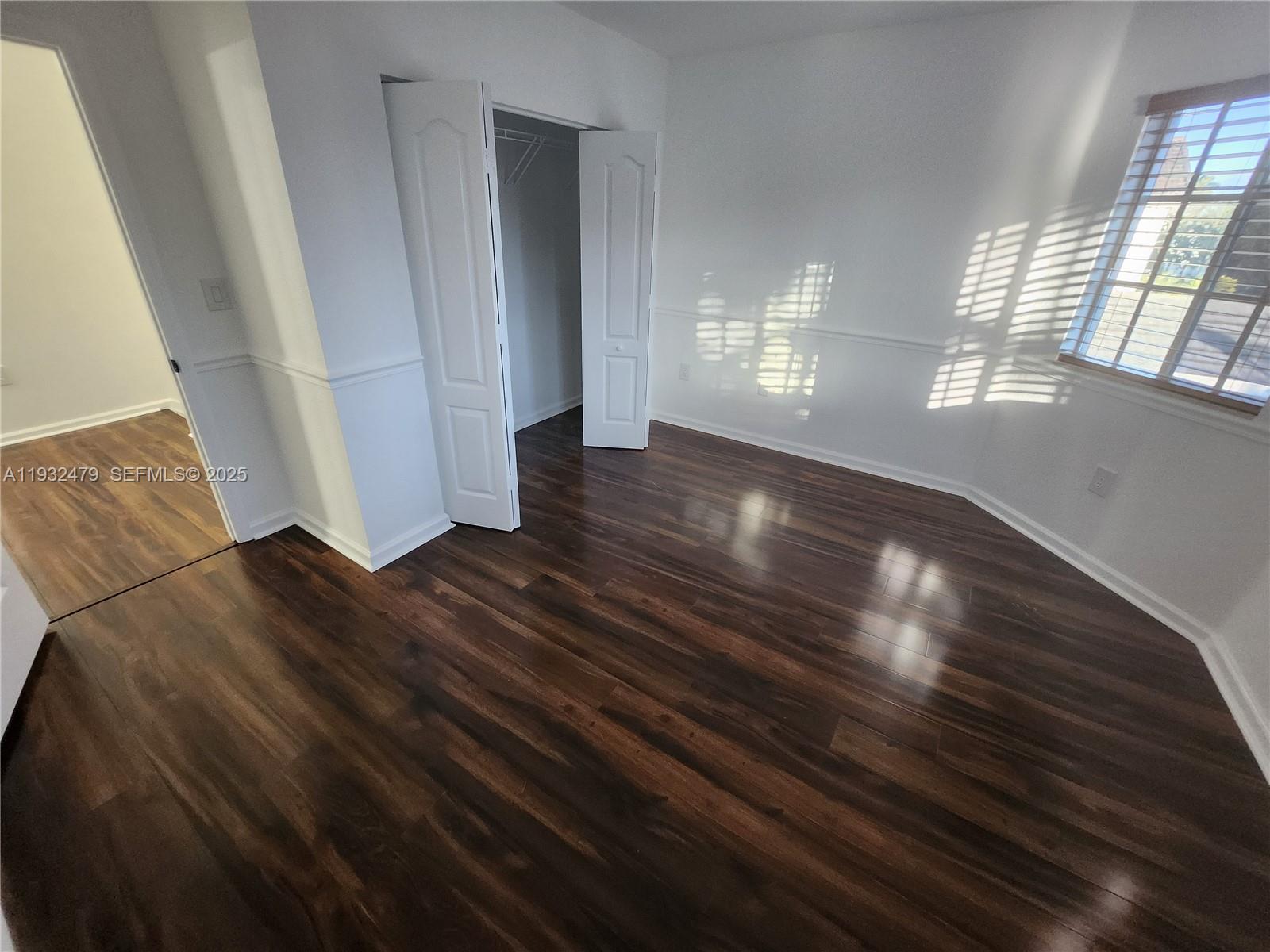 13973 Southwest 276th Way Homestead, FL 33032 - Photo 23 of 43 wooden floor in an empty room with a window