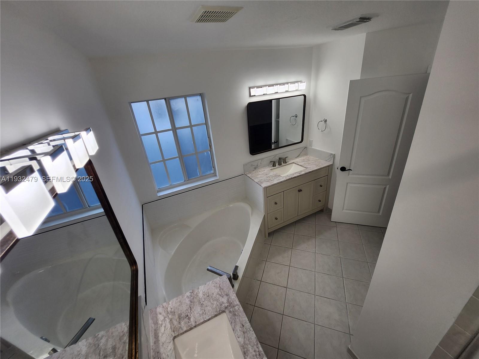 13973 Southwest 276th Way Homestead, FL 33032 - Photo 36 of 43 a bathroom with a sink a mirror and a bathtub