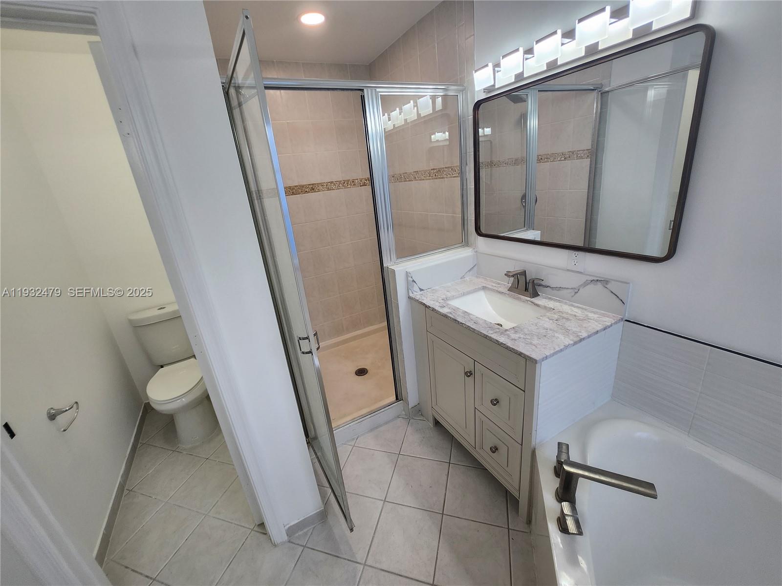 13973 Southwest 276th Way Homestead, FL 33032 - Photo 38 of 43 a bathroom with a granite countertop sink toilet and mirror