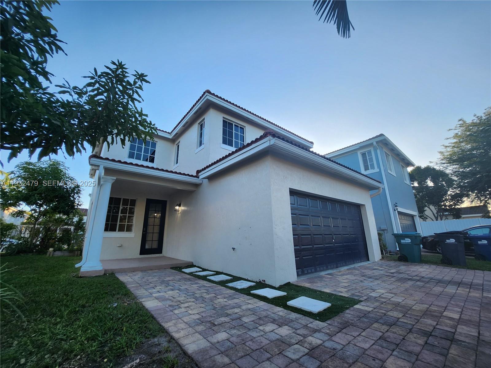 13973 Southwest 276th Way Homestead, FL 33032 - Photo 40 of 43 a front view of a house with a yard and garage